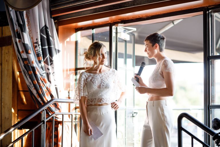 Brides give speech to each other at their wedding at The Mud Dock