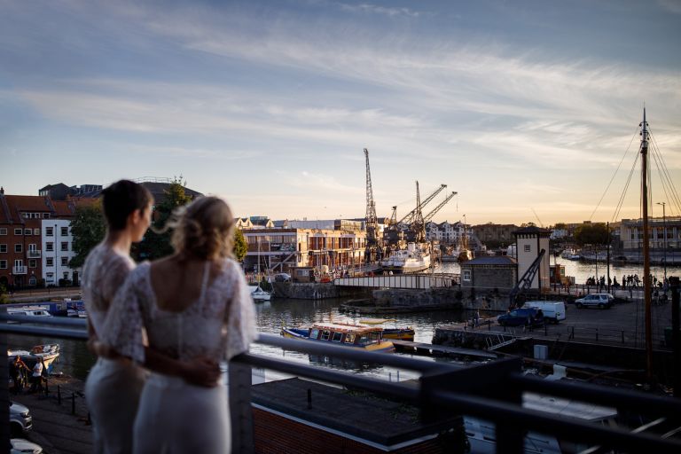 Brides look out over view from the balcony at the Mud Dock Bristol