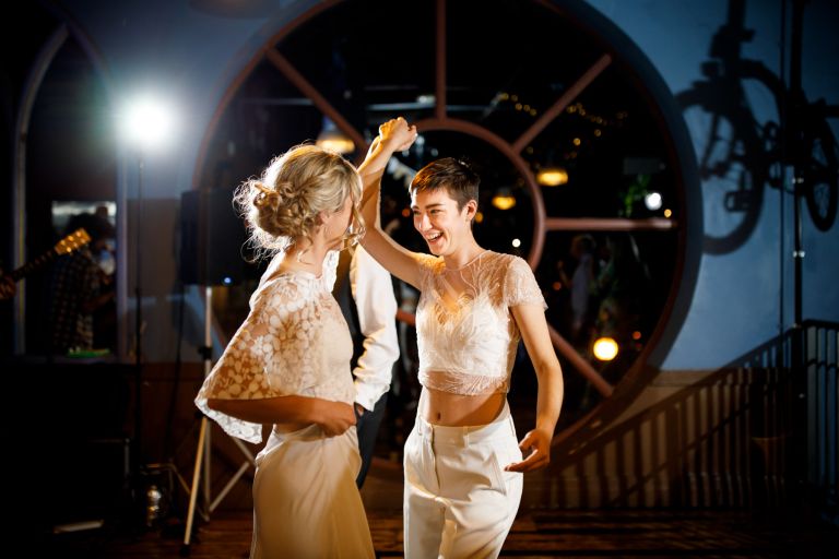 Couple first dance in front of the round window at the Mud Dock 