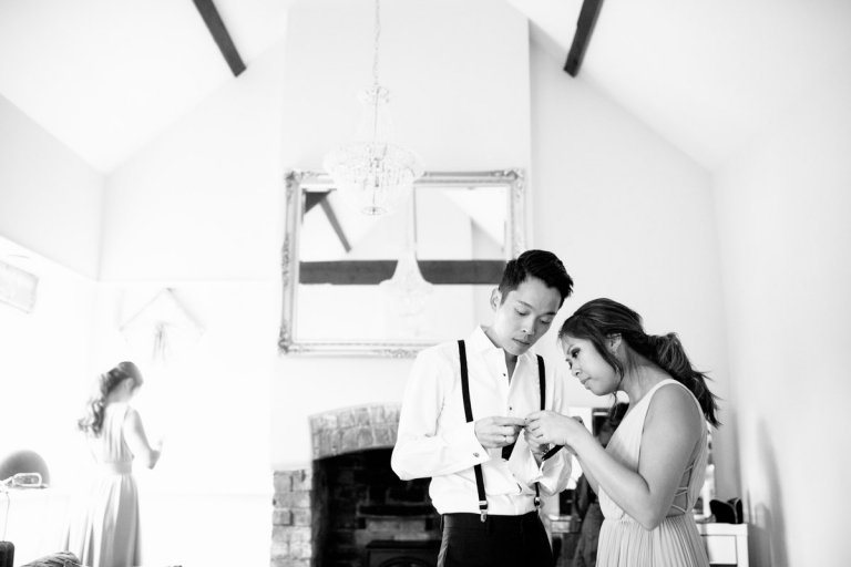 Berkeley Castle Wedding - groomsmaid helps groom get ready
