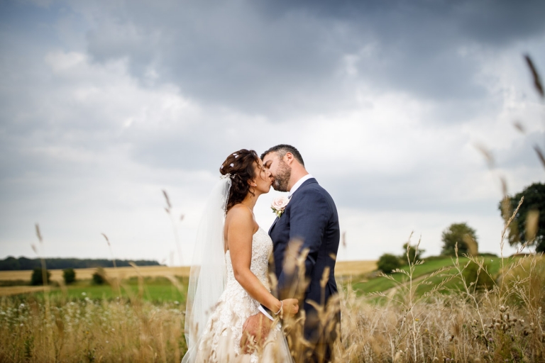 Couple kiss in stone barn wedding photos