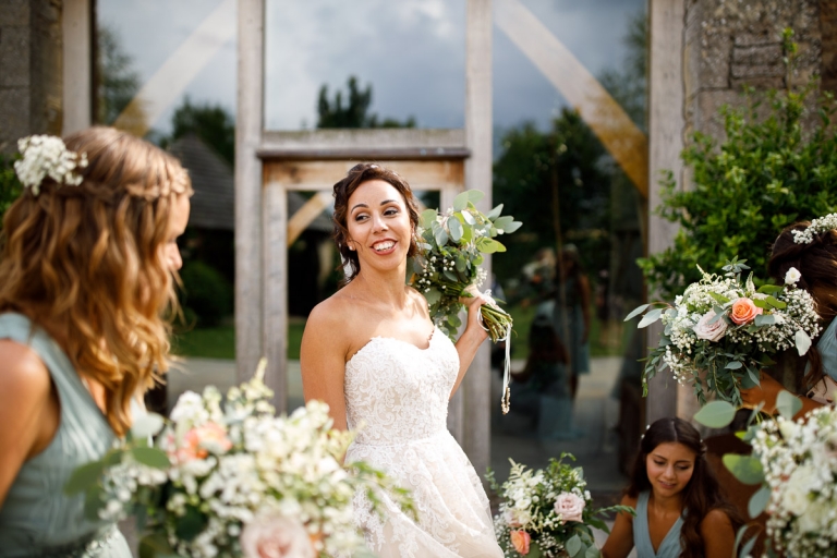 Bride with her bridesmaids naturally at cripps stone barn