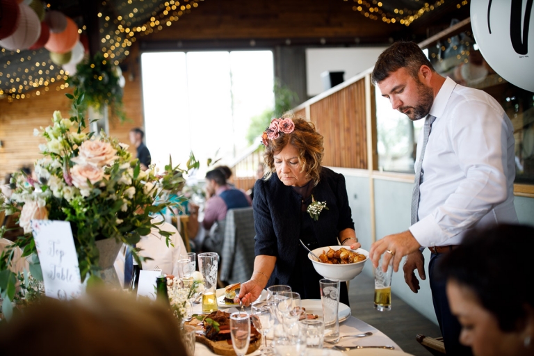 Groom and his Mum dish up food for wedding breakfast at Cripps Stone Barn Wedding