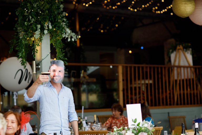 Guest wears mask of groom at wedding at Cripps Stone Barn