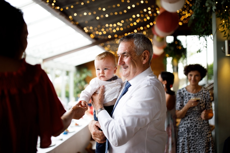 Father of Groom holds his grandchild at wedding at Cripps Stone Barn