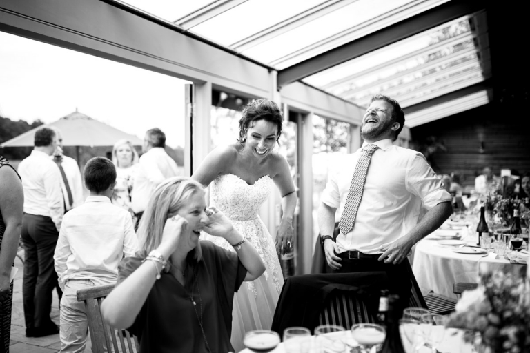 Guests laughing with bride at wedding at Stone Barn