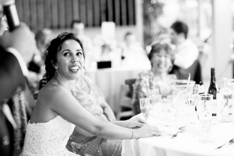 bride looks at groom during his speech at cripps stone barn