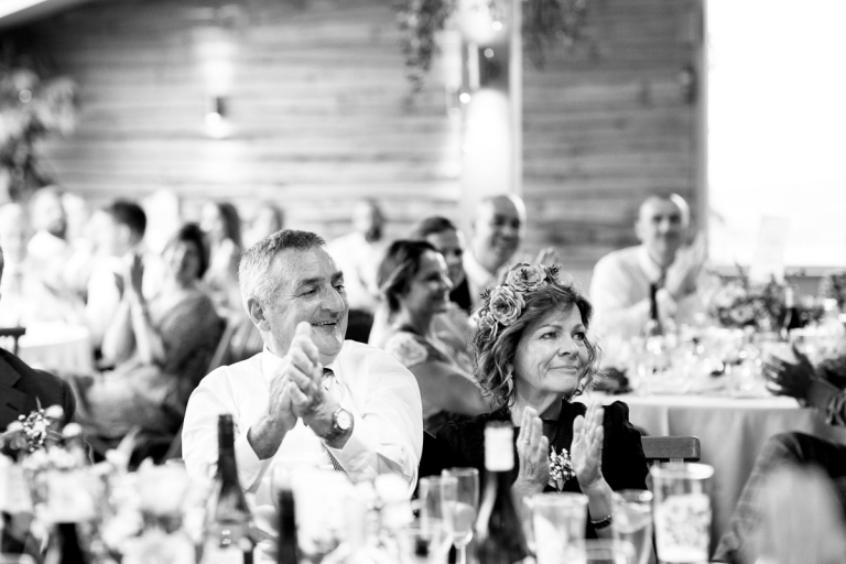 Grooms parents clap and look emotional during grooms speech at cripps stone barn