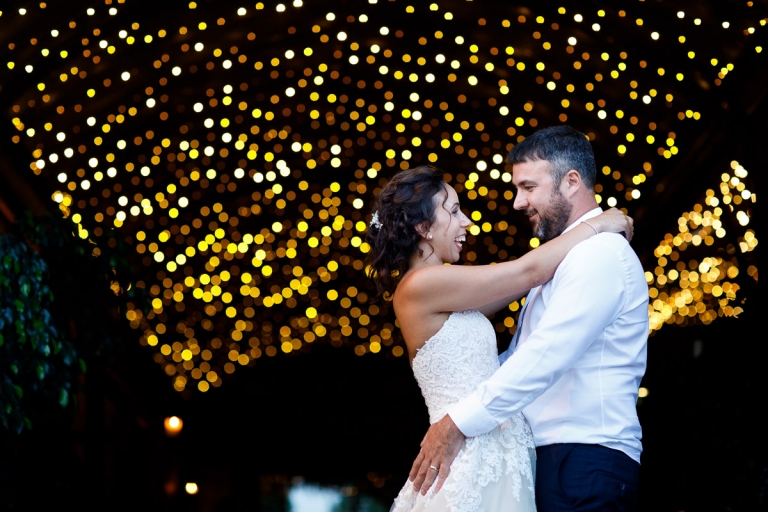 Couple snuggle with fairy lights at cripps stone barn