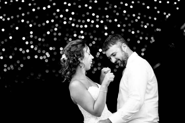 Couple dance with fairy lights in the background at cripps stone barn