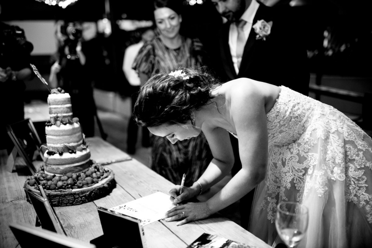 Bride signs certificate at cripps stone barn wedding