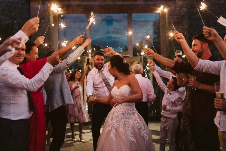 Couple dance under sparklers at cripps stone barn