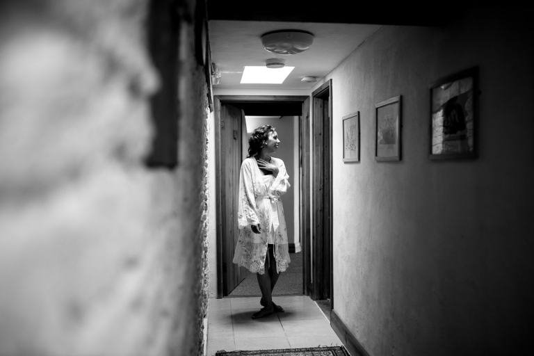 bride wears bridal dressing gown as she waits to get ready for Cripps Barn