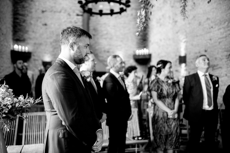 Emotional groom as bride approaches for ceremony in the Stone Barn