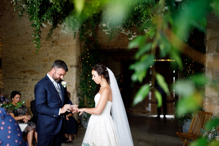 Couple exchange rings during ceremony at Cripps Stone Barn