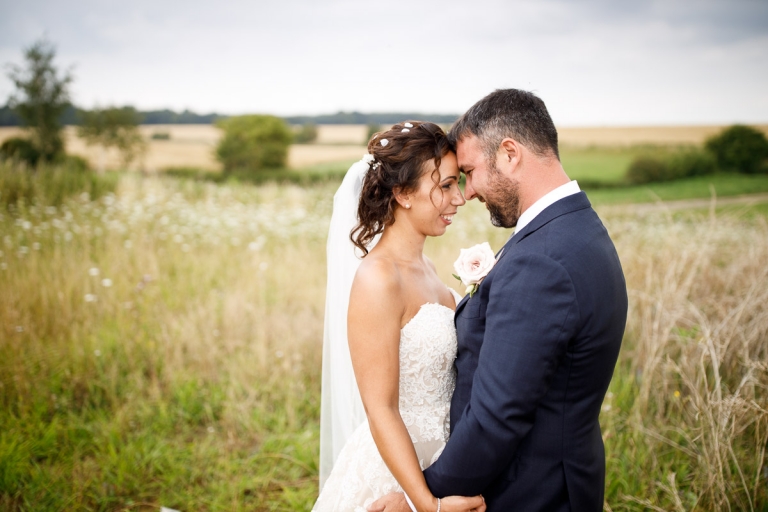 Couple snuggle in long grass at Cripps stone barn