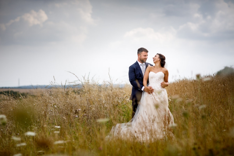 Couple laugh in stone barn wedding photos