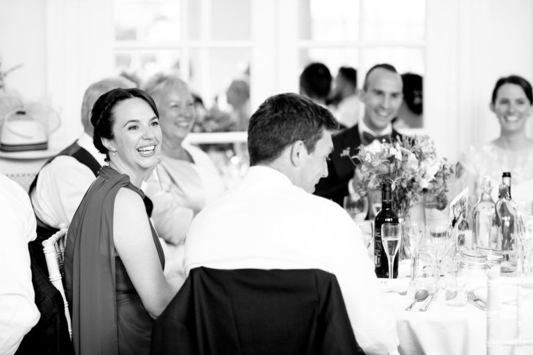 bridesmaid laughs at the bestmans speech during wedding speeches at the orangery in bristol