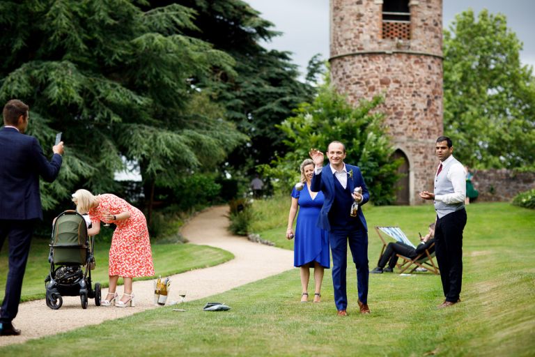 Guests playing boules with the tower in the background at a wedding in the gardens in goldney hall