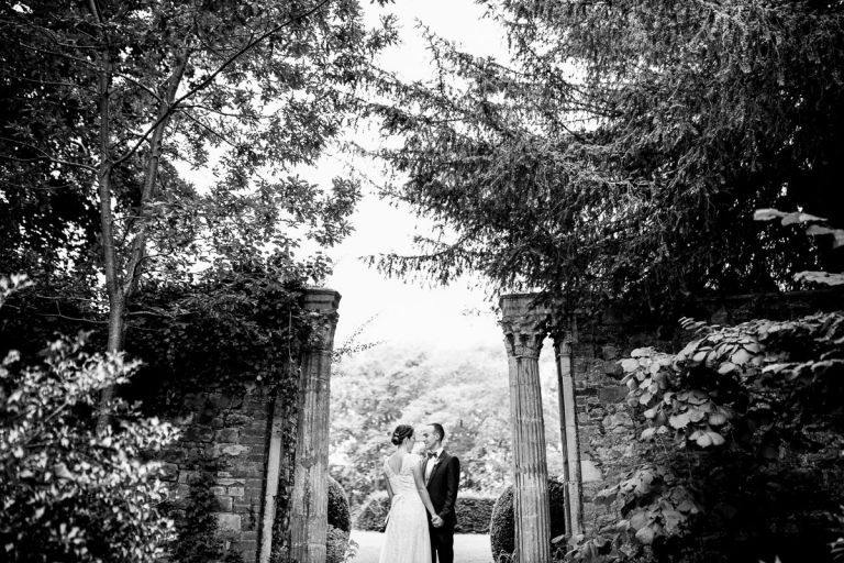 couple look at each other in the classical garden ornaments at goldney house, photo in black and white