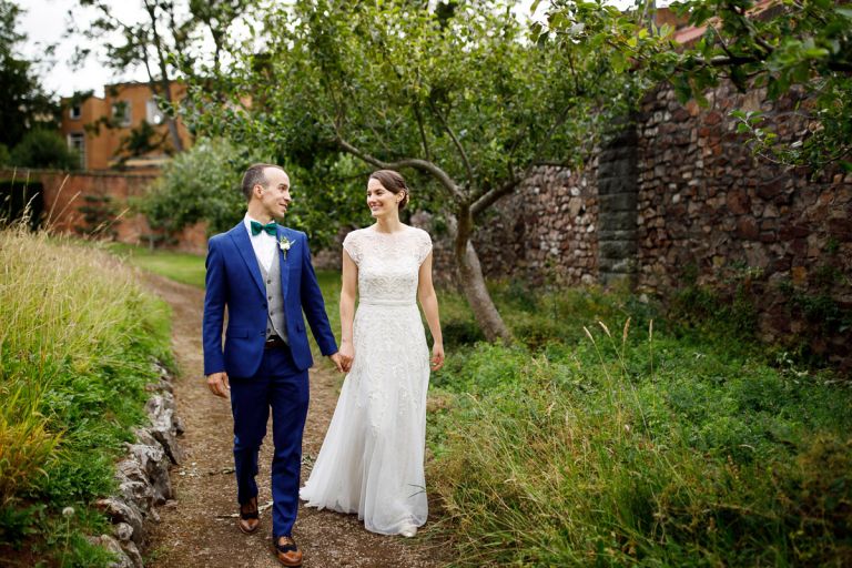 Couple walk hand in hand outside at their wedding at goldney hall