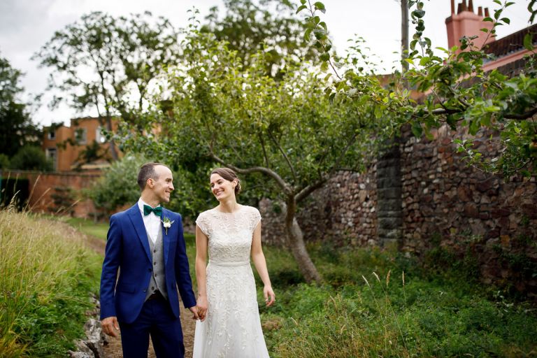 couple walk through the orchard at goldney hall inside the walls