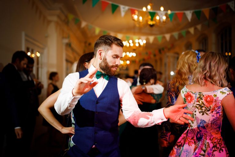 Guest dances with bunting and lights from the decoration of the orangery at goldney hall
