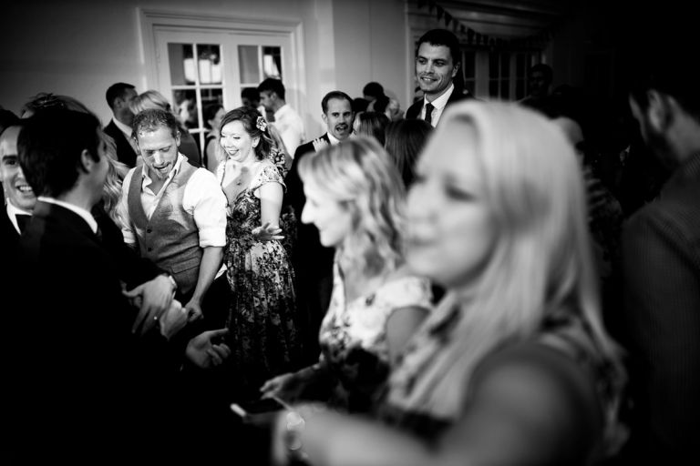 best man and friend dance togerher on a crowded dance floor in the orangery at goldney house