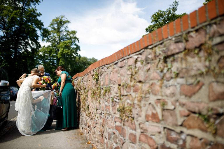 Bride has dress arranged by bridesmaids on the streets of clifton, bristol