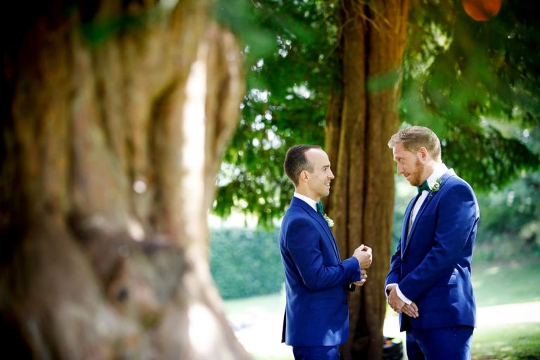 groom and bestman chat as they wait in the trees in the gardens of goldney house before the ceremony