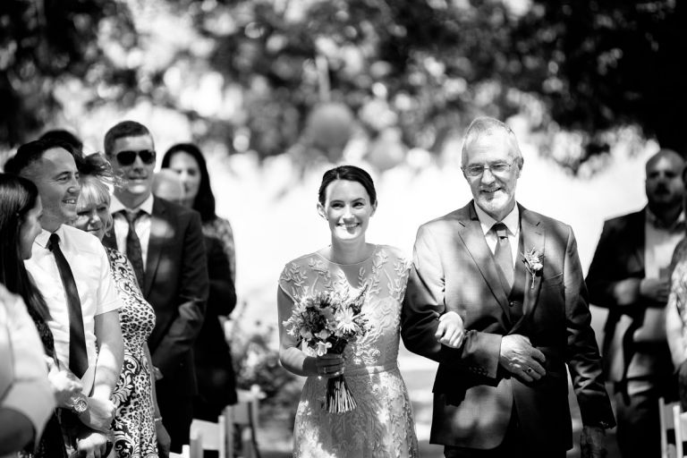 black and white photo of the bride and her dad walking down the aisle at goldney hall 