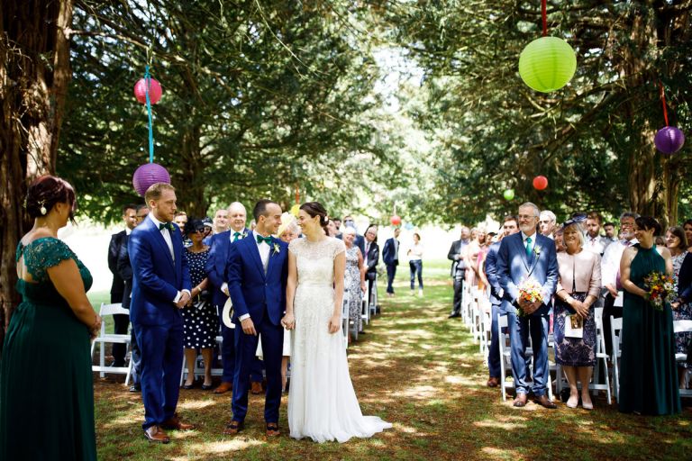 bride and groom see each other for the first time under the trees at the start of their outside wedding at goldney hall