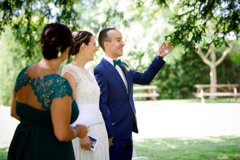 groom holds up image during outside wedding ceremony in bristol