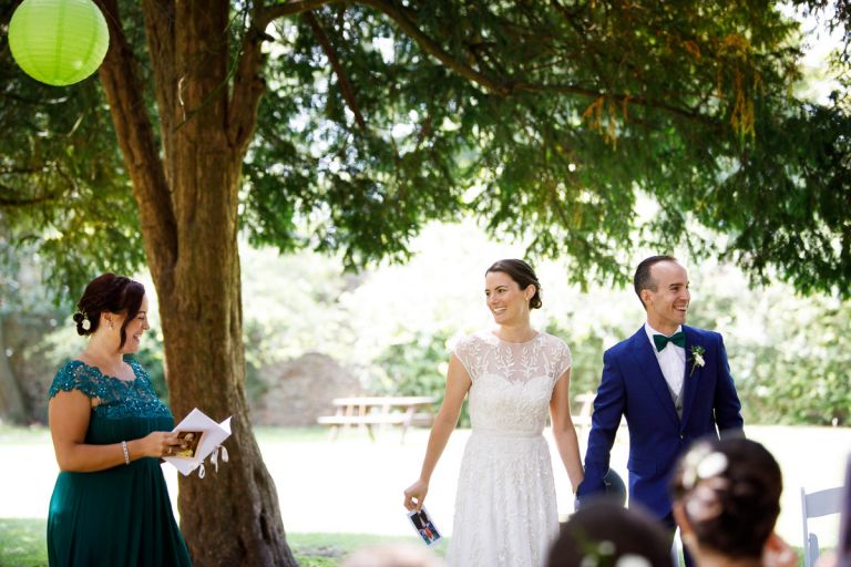 couple and celebrant laugh during ceremony game in outdoors wedding ceremony bristol