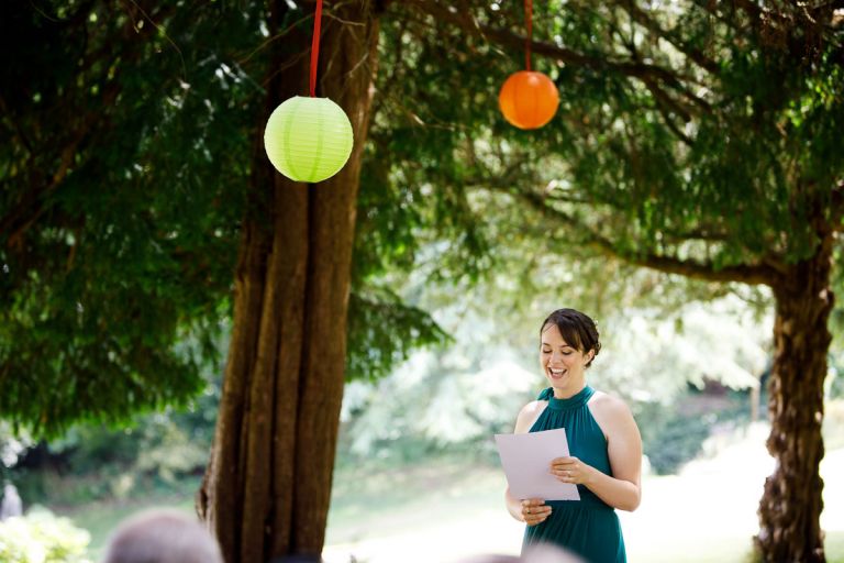 brides sister does a personal reading under the trees and lanterns in the gardens of goldney house