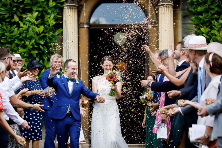 Couple walk out to lots of confetti outside Goldney House
