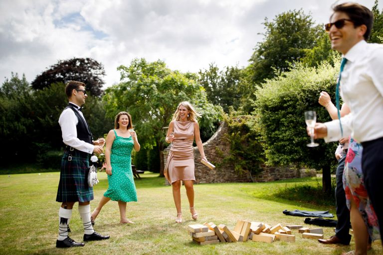 Guests playing giant jenga in the gardens at wedding venue goldney house
