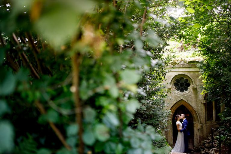 Couple kissing in the grotto doorway in goldney hall gardens, lots of greenery surrounding them