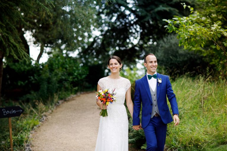 Couple walking along smiling at their guests as they walk back to their wedding in clifton