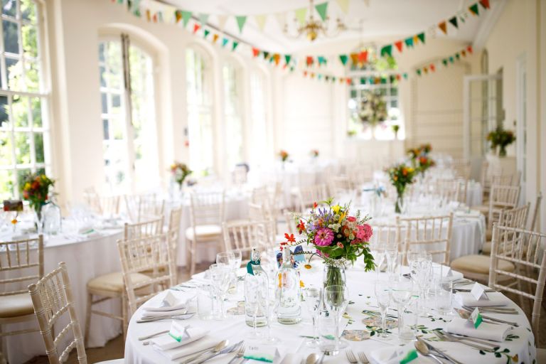 Inside the orangery at goldney hall decorated with colourful flowers and bunting