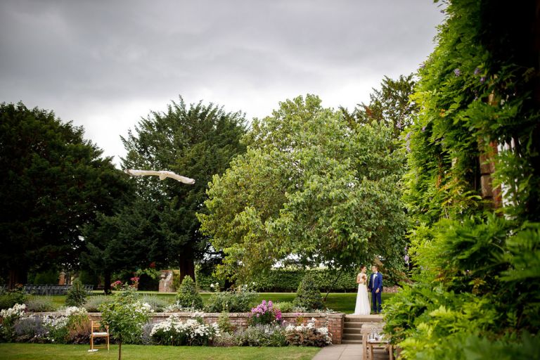 Couple wait for their guests to be seating before being announced into the room, a big seagull sweeps across in the gardens at goldney house