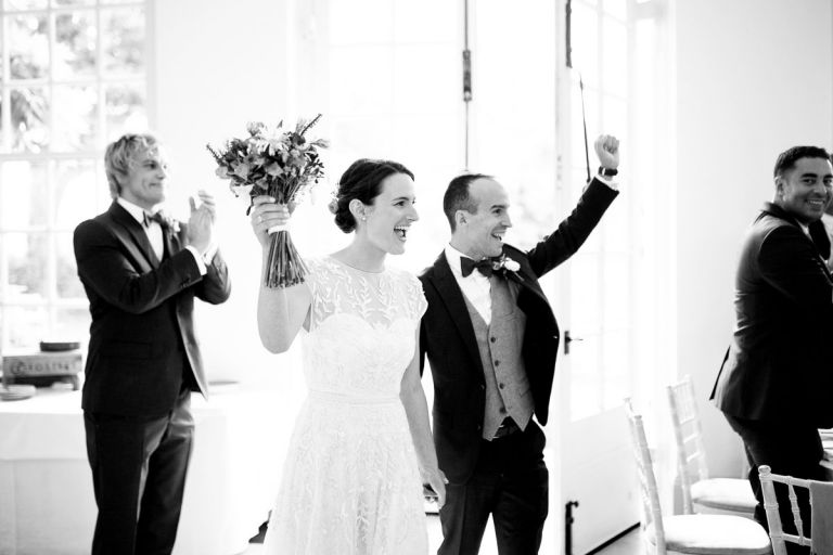Couple celebrate and punch the air as they are announced into their wedding breakfast at the orangery, bristol