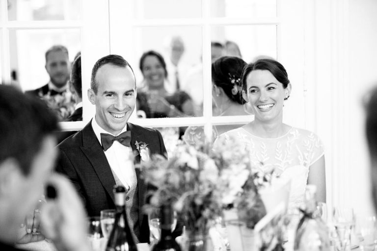 bride and groom laughing during the brides dads speech