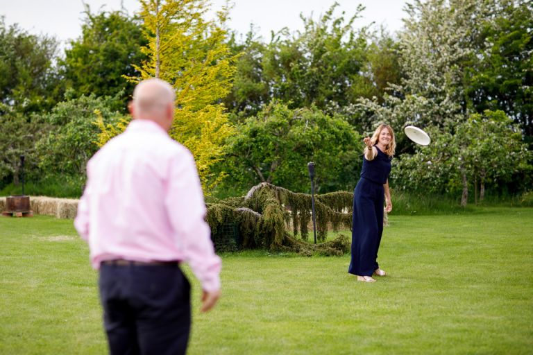 Couple play frisbee during wedding reception, games at weddings