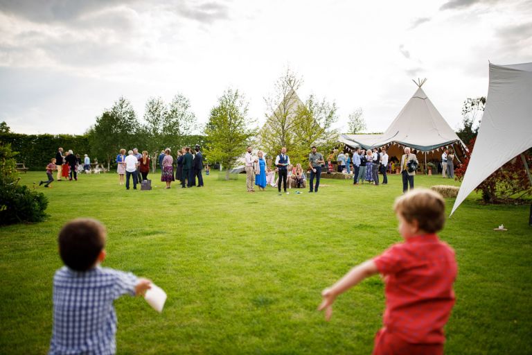 Guests in background in focus throwing things to the kids in the foreground which are out of focus. 