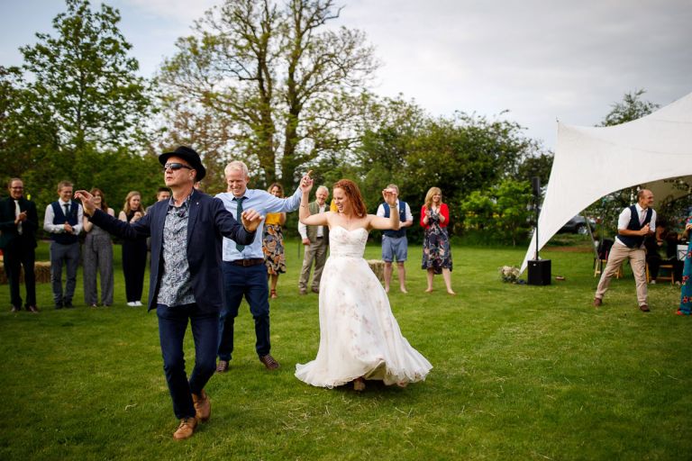 Couple start their first dance as part of a ceilidh outside at their wedding reception