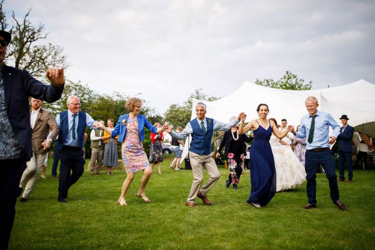 Couple bring in wedding party during their outside first dance 