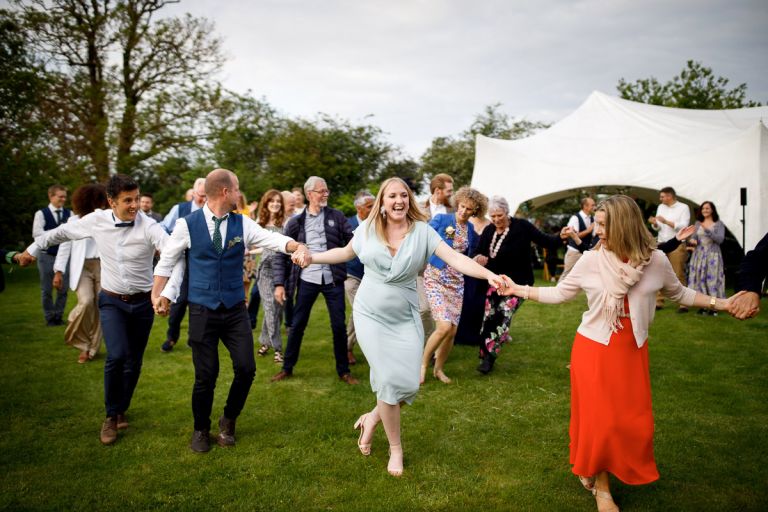 Guests join in with the outside ceilidh at wedding 