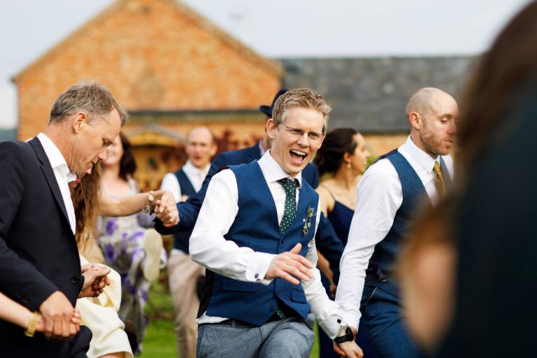 Groomsman at wedding dances as part of the outside ceilidh 
