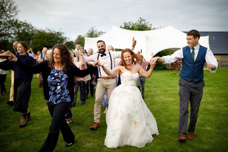 Bride joins in with guests during outside ceilidh